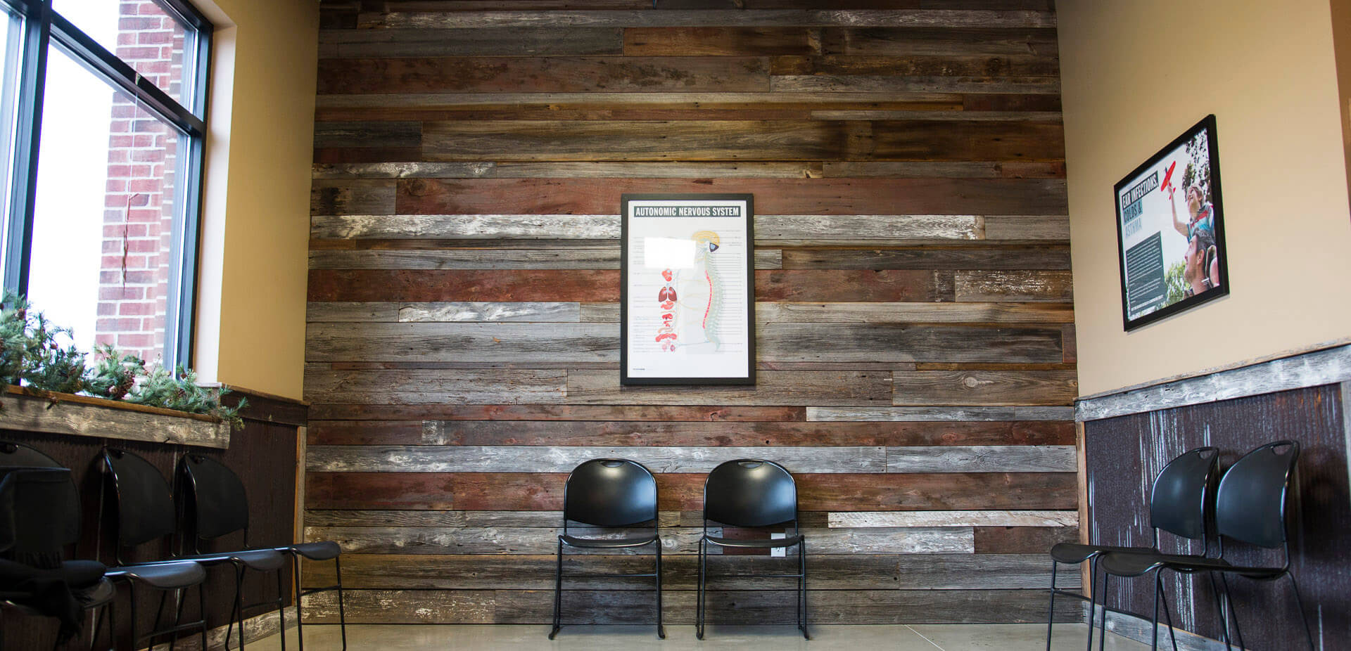 Two black chairs in front of a wooden wall.