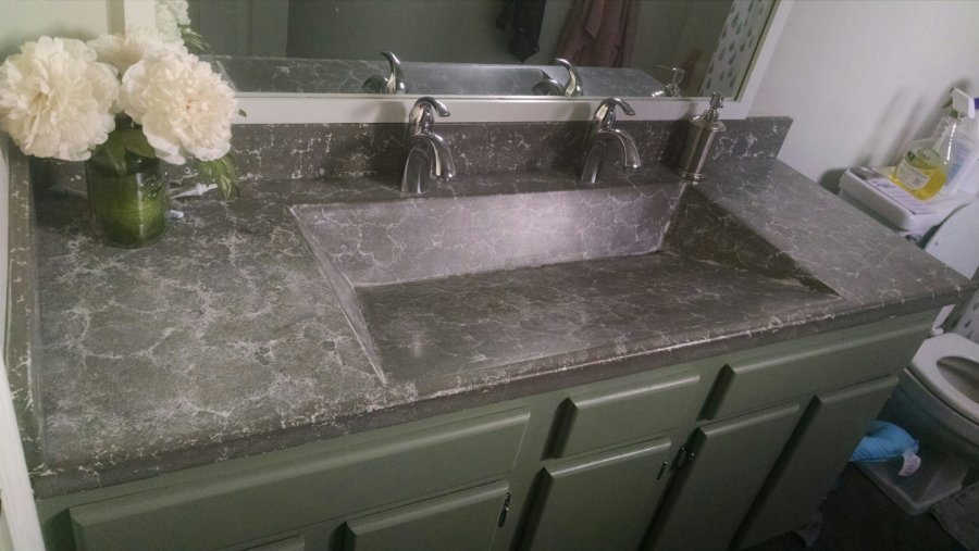 A bathroom sink with two faucets and a mirror.
