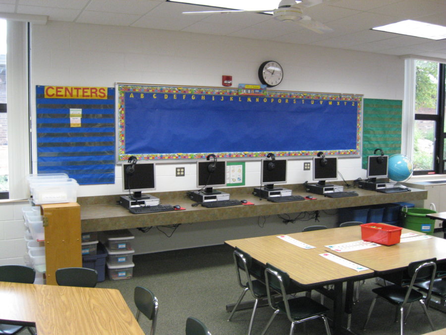 A classroom with desks and computers on it.