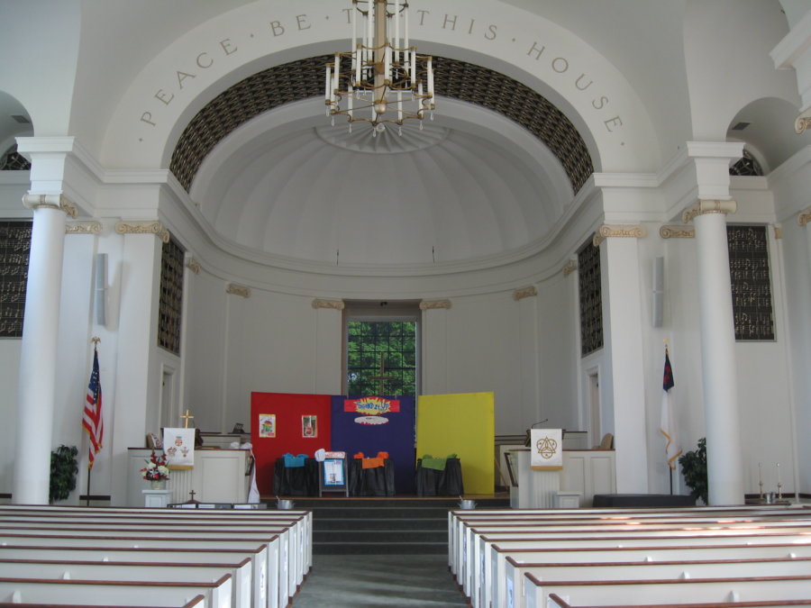 A church with pews and a large arch in the center.