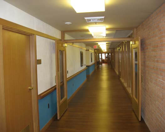 A long hallway with wooden floors and blue walls.