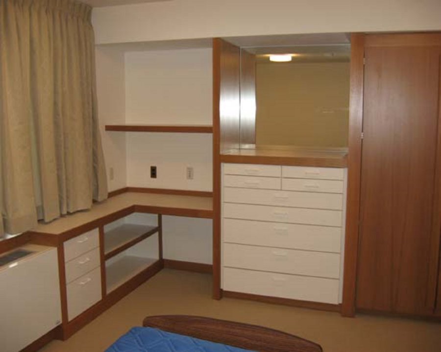 A bedroom with a bed, dresser and closet.