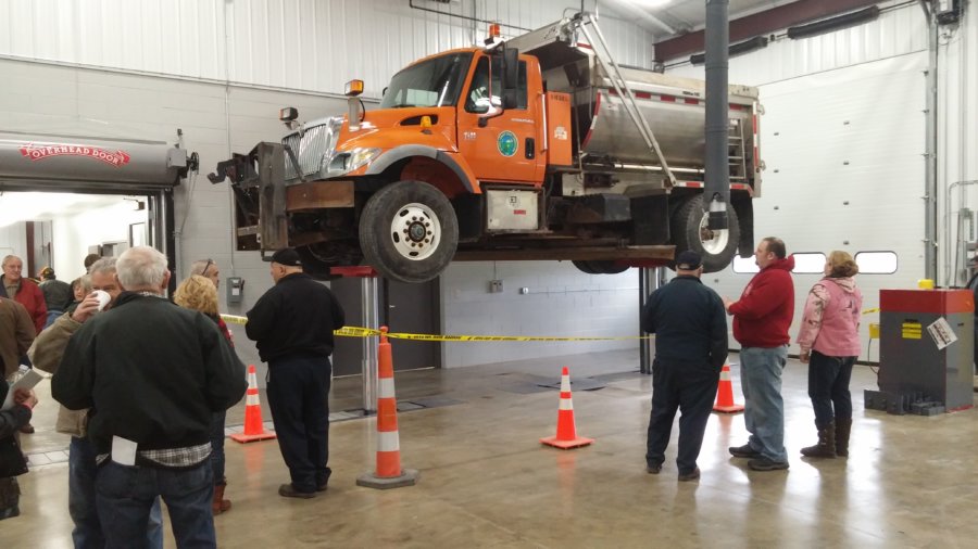 A large truck is being lifted by orange cones.